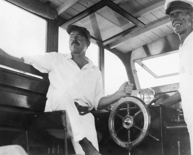 Эрнест Хемингуэй за штурвалом своей яхты "Пилар" с Карлосом Гутьерресом